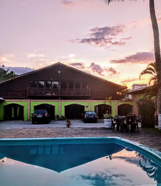 a house with a swimming pool in front of a house at Pousada Flor de Jambo in Ubatuba