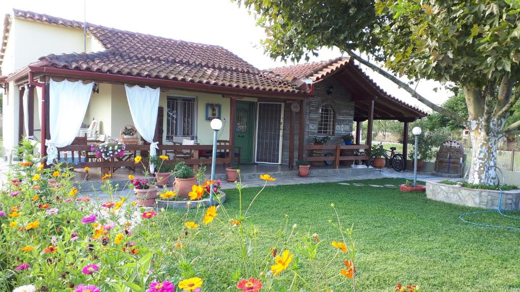 a house with a garden with flowers in the yard at Platanos House in Néa Meságkala