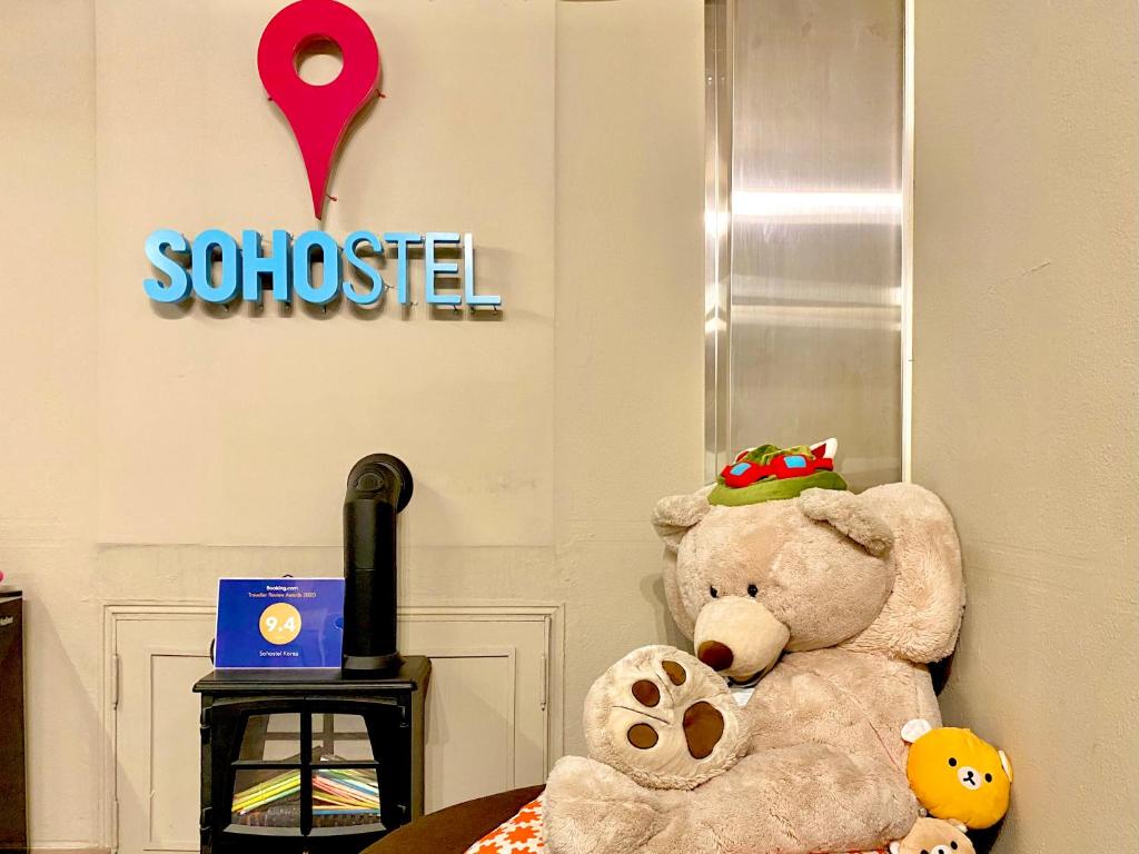 Un ours en peluche assis sur une table dans une pièce dans l'établissement Sohostel Korea, à Busan