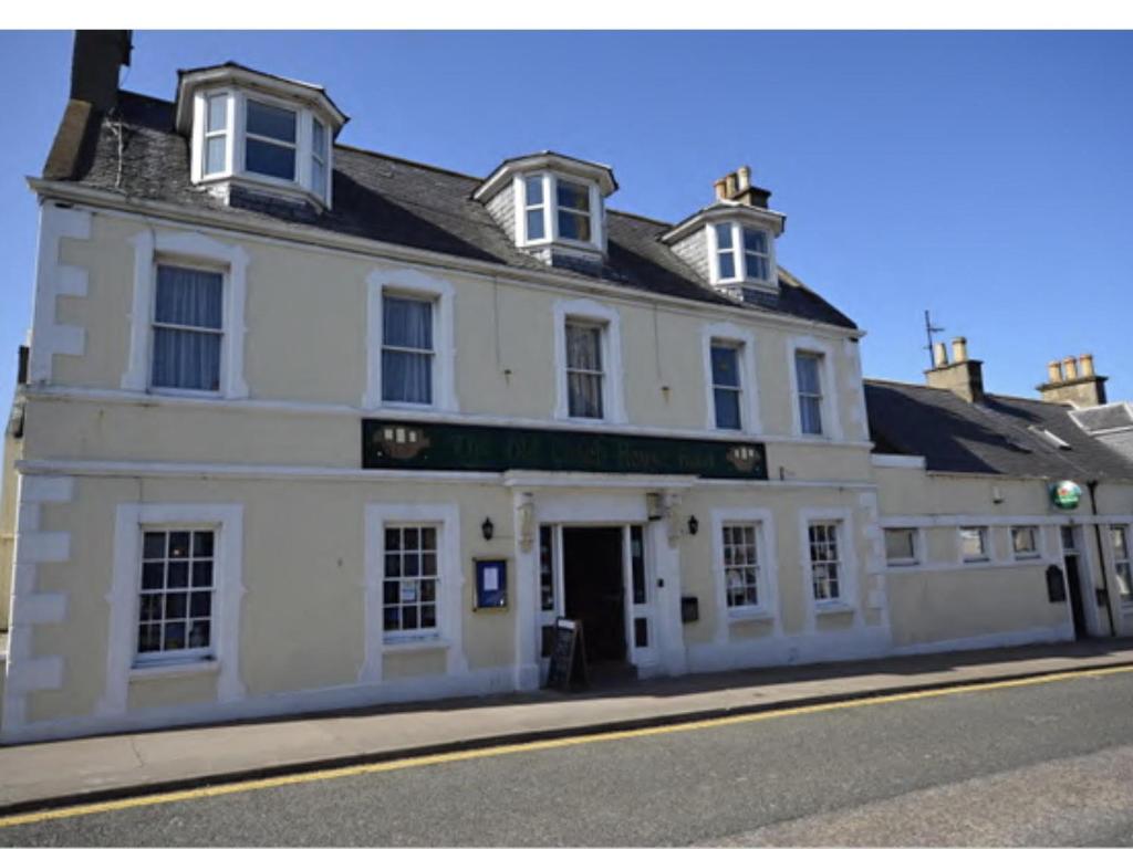 a white building on the side of a street at The Old Coach House in Buckie