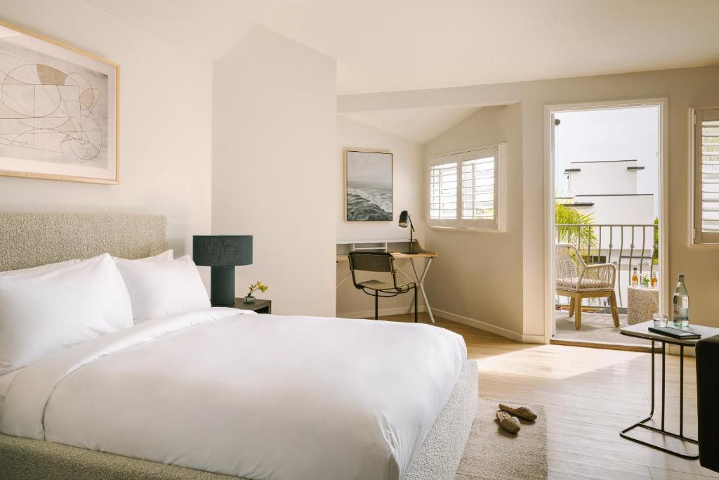 1 dormitorio con cama blanca y balcón en Sonder La Ensenada, en Laguna Beach