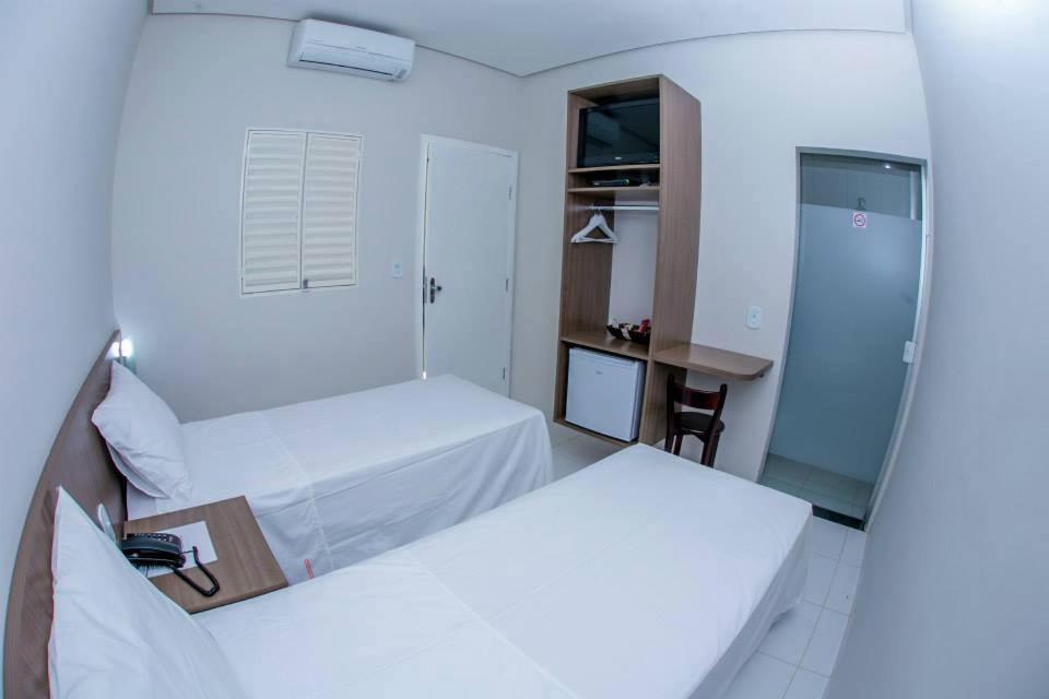 A bed or beds in a room at Hotel Império