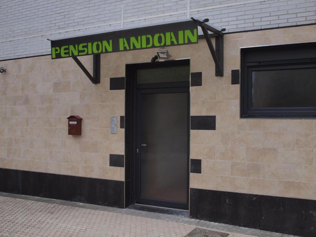 un edificio con una puerta y un cartel que lee la información del permiso en Pension Andoain, en Andoain