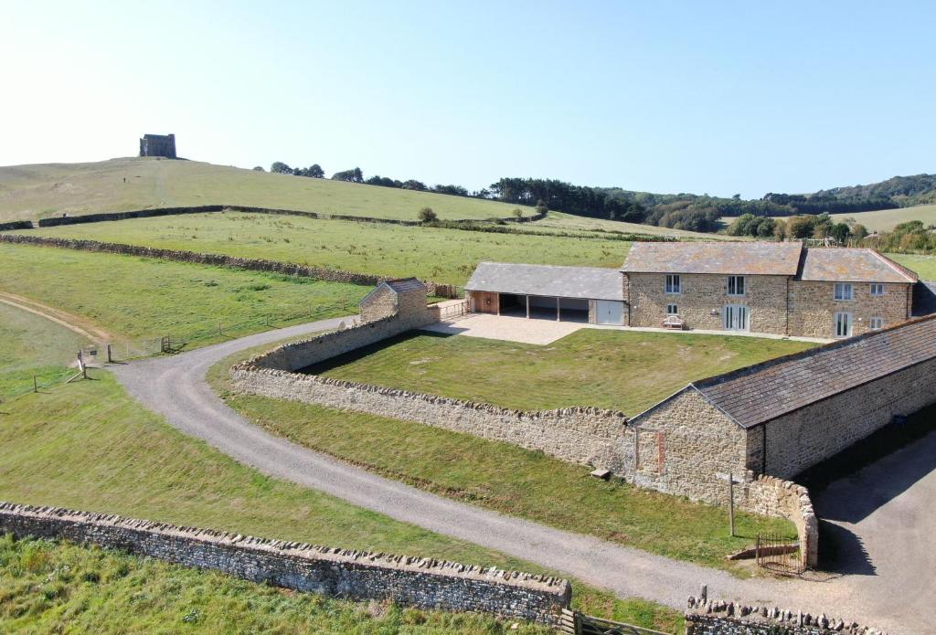 uma casa no topo de uma colina com uma estrada em Furlongs em Abbotsbury