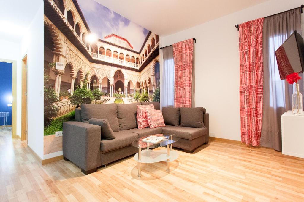 una sala de estar con un sofá y una mesa en Apartamentos Diaber Laraña, en Sevilla