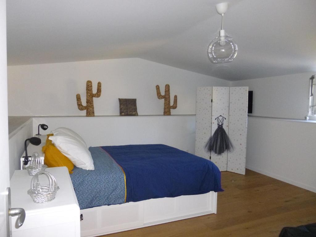 1 dormitorio con cama y cactus en la pared en LES RIVES DE LA DIVE les chambres 123 coaching, en Moncontour-de-Poitou