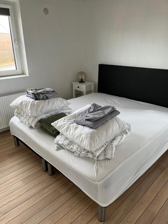 uma cama com lençóis brancos e almofadas em Casa Markskellet, Billund - hygge og leg for alle em Billund