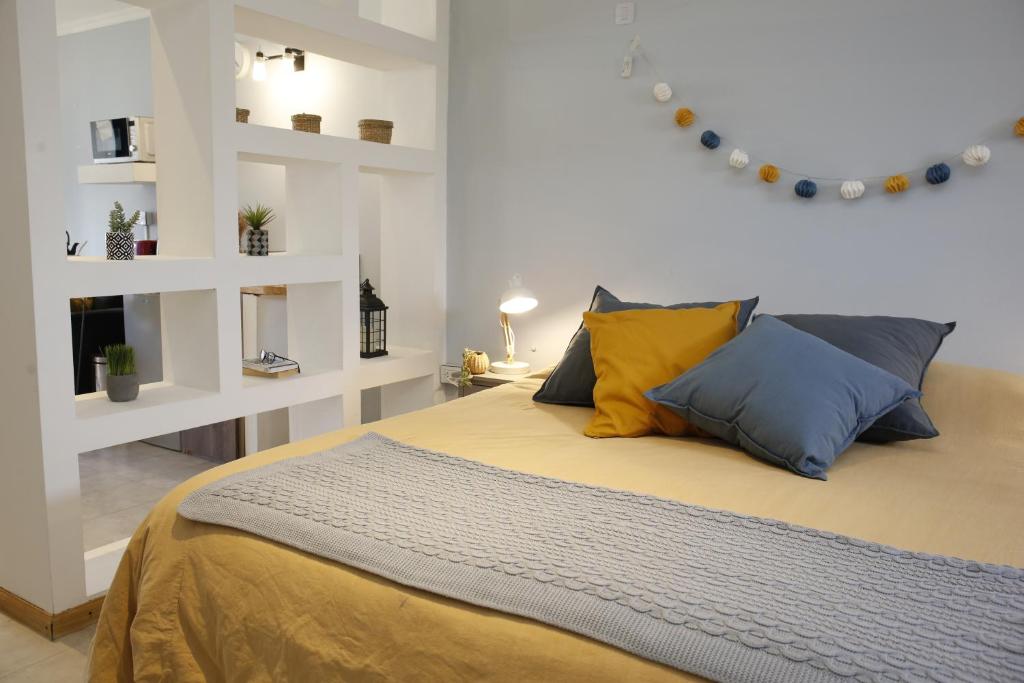 a bedroom with a bed with blue and yellow pillows at Studio Toro in El Chalten