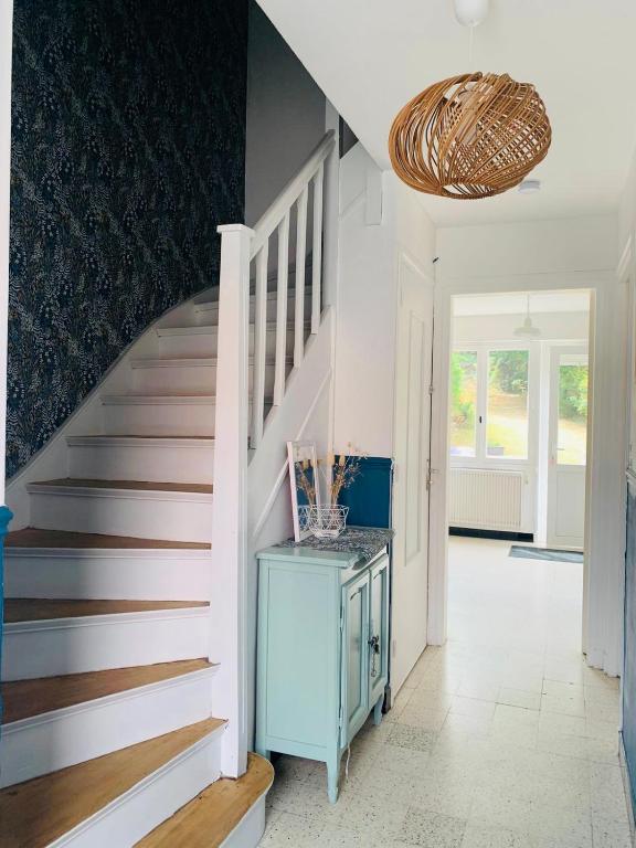 a hallway with a staircase with a blue cabinet at Entre mer et falaises in Équihen-Plage