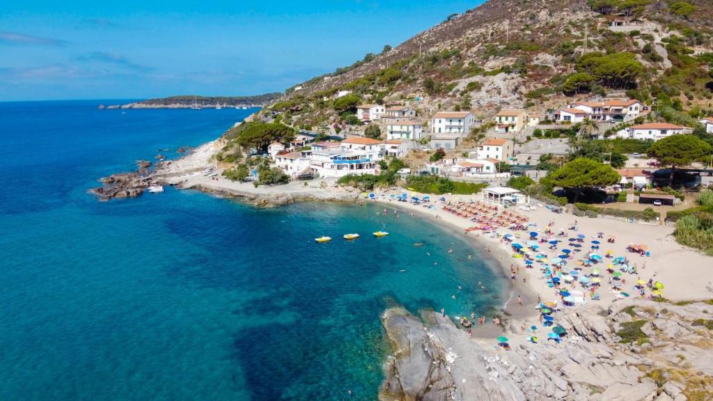 eine Luftansicht auf einen Strand mit Menschen im Wasser in der Unterkunft Hotel La Stella in Seccheto