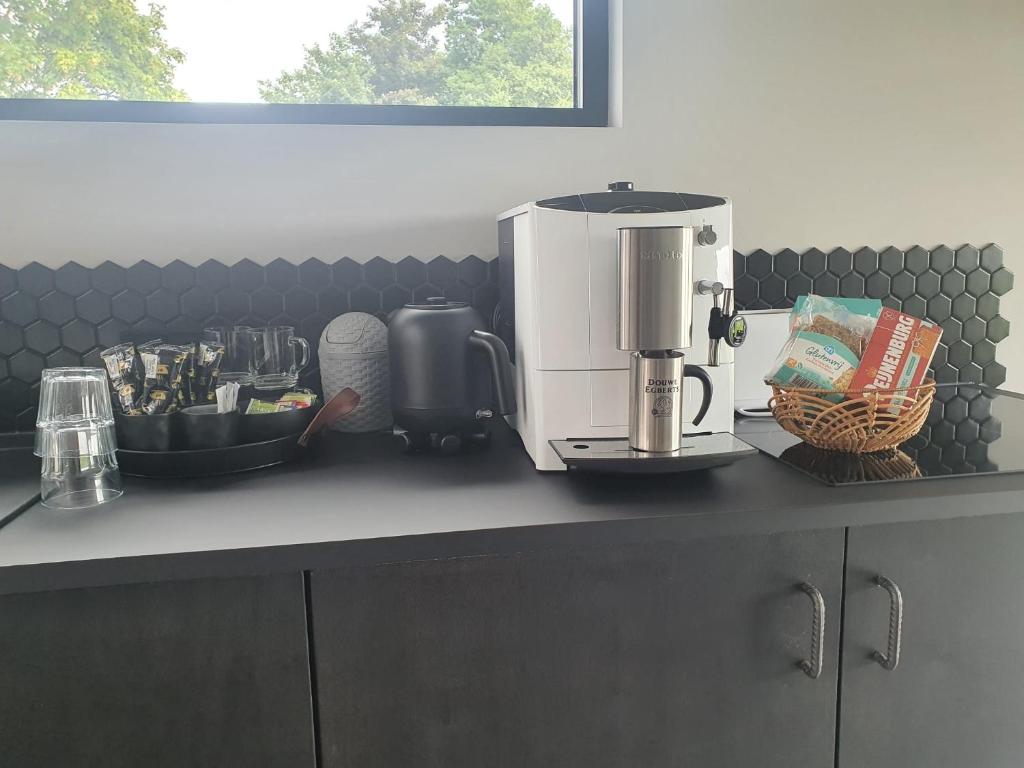 a coffee maker on a counter in a kitchen at Hippe Schuur in Tietjerk
