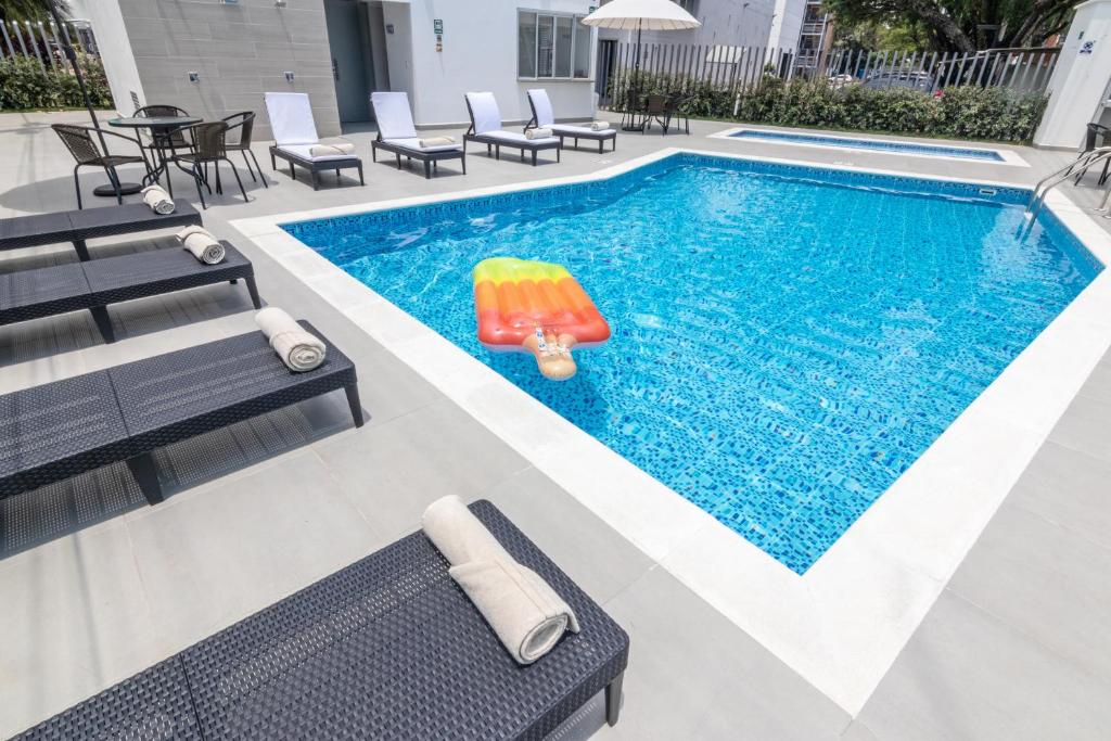 uma piscina com cadeiras e um brinquedo insuflável em GHL Hotel Neiva em Neiva