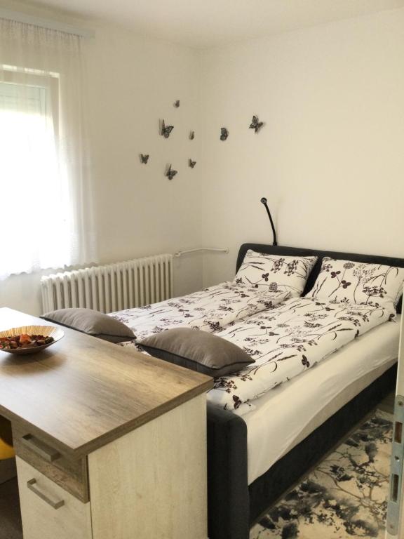 a bedroom with a bed with a table and birds on the wall at Apartman * VICTORY * in Banja Luka