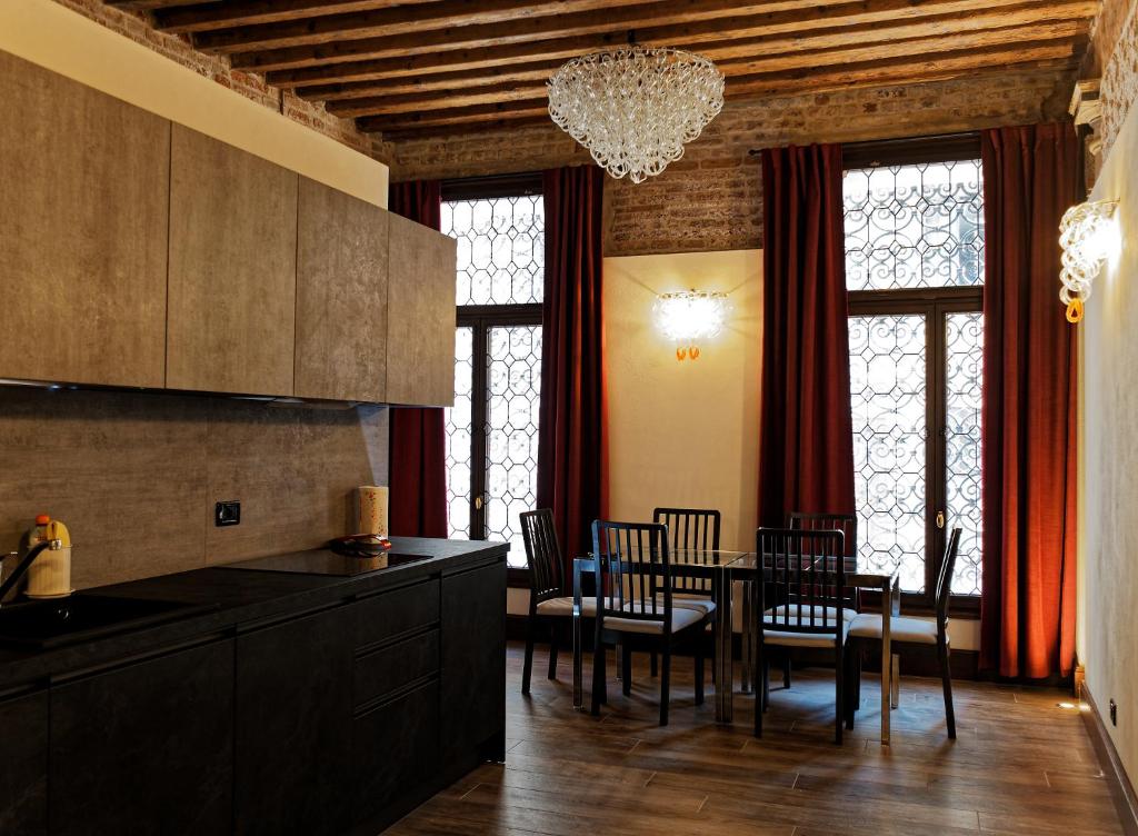 cocina y comedor con mesa y sillas en Gradenigo Apartments 767, en Venecia