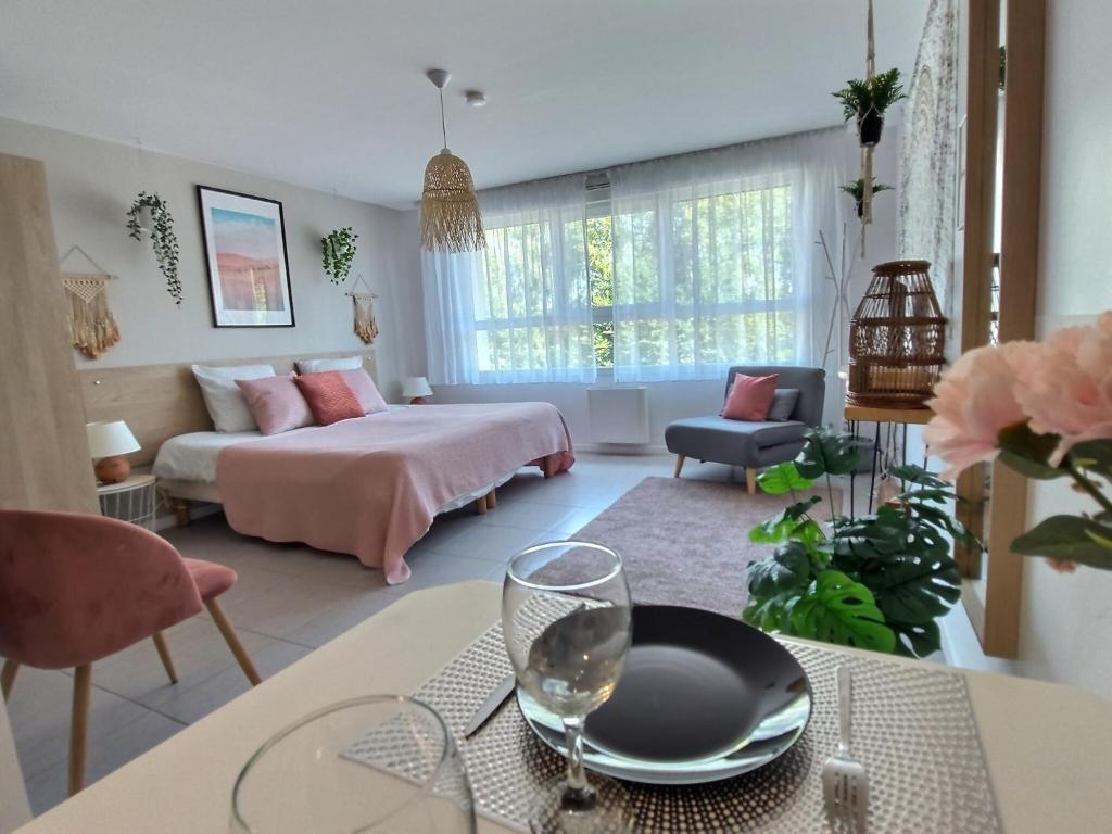 Un dormitorio con una cama y una mesa con un plato. en L'AMAZONIE - ROISSY CDG - Parc Astérix - Paris en Moussy-le-Neuf