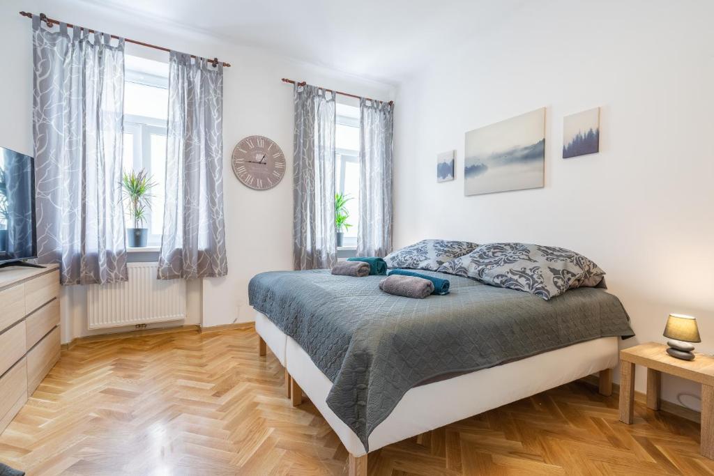 1 dormitorio con 1 cama y reloj en la pared en revLIVING Apartments Eggenburg - Garten - Netflix - Disney Plus - Nespresso en Eggenburg