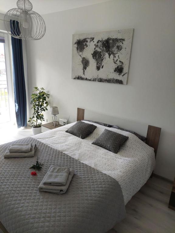 a bedroom with a bed with two towels on it at Apartament Kopernika-centrum Słupska in Słupsk