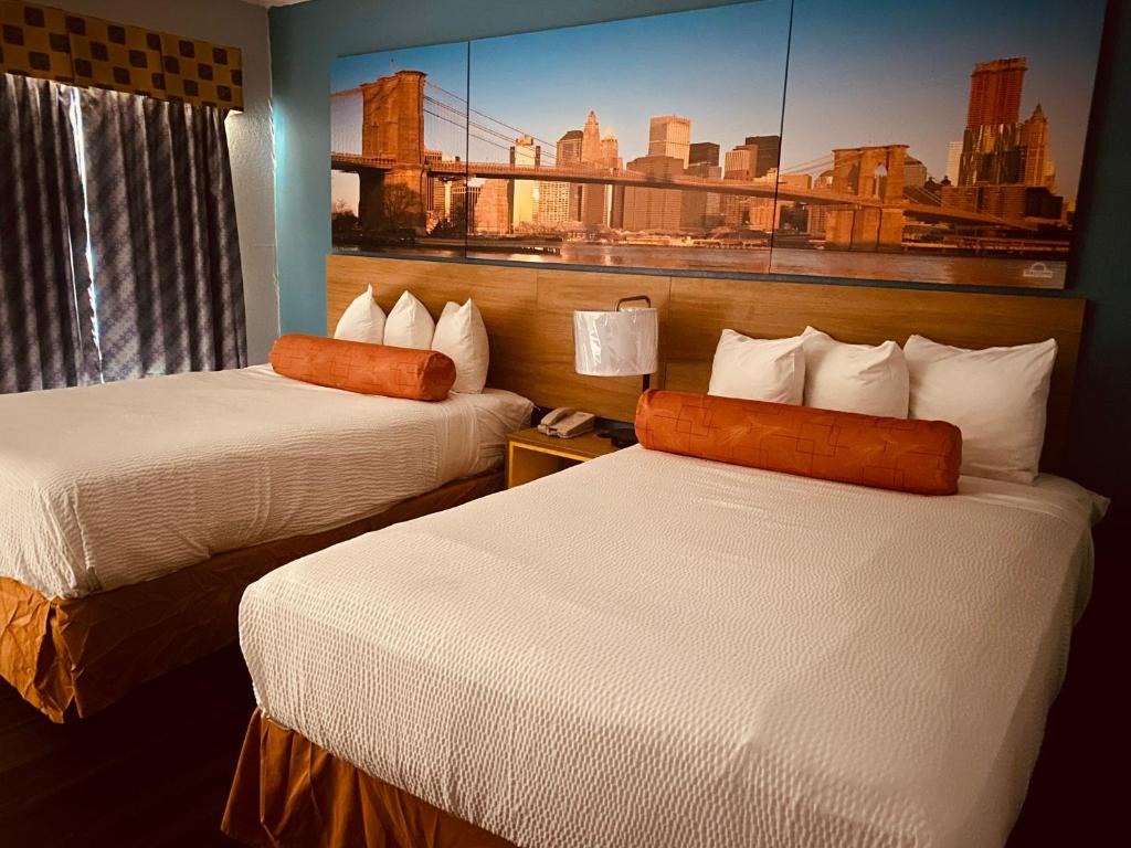 una habitación de hotel con 2 camas y un cuadro en la pared en Days Inn by Wyndham Queensbury/Lake George en Queensbury