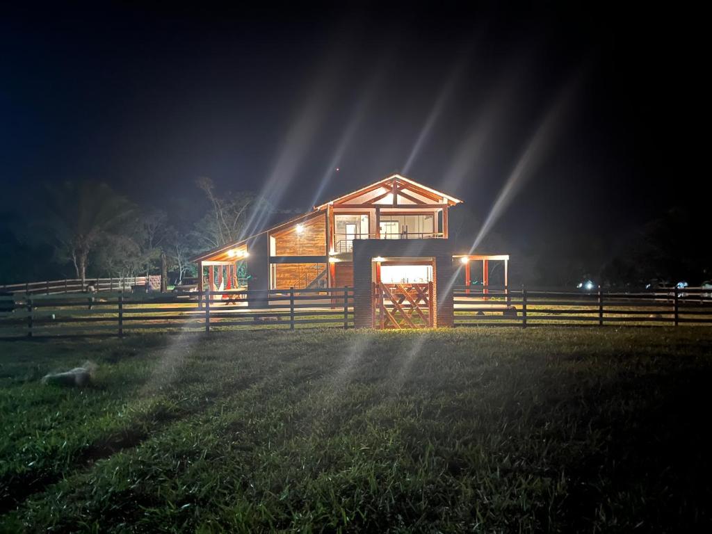 a wooden cabin with lights in a field at night at Cabaña Los Sauces en Buena Vista Santa Cruz in Buena Vista