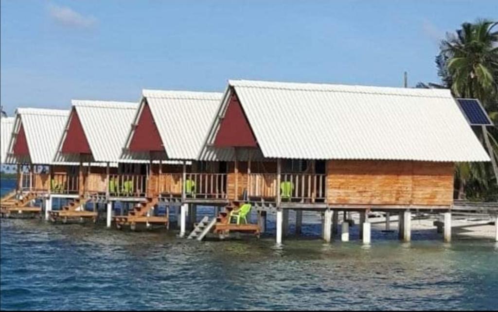 a row of houses on a dock in the water at Cabañas Waili in Niatupo