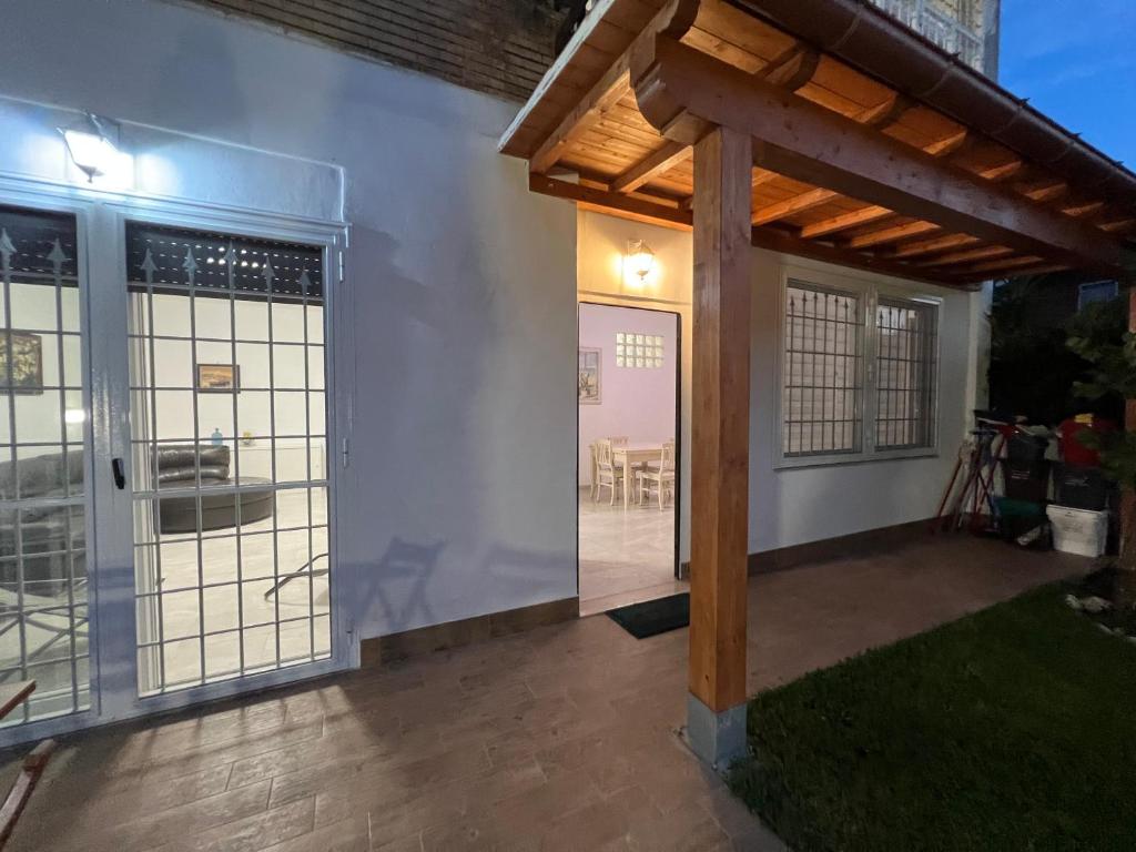 a patio with sliding glass doors and a wooden pergola at Casaflavio in Torvaianica