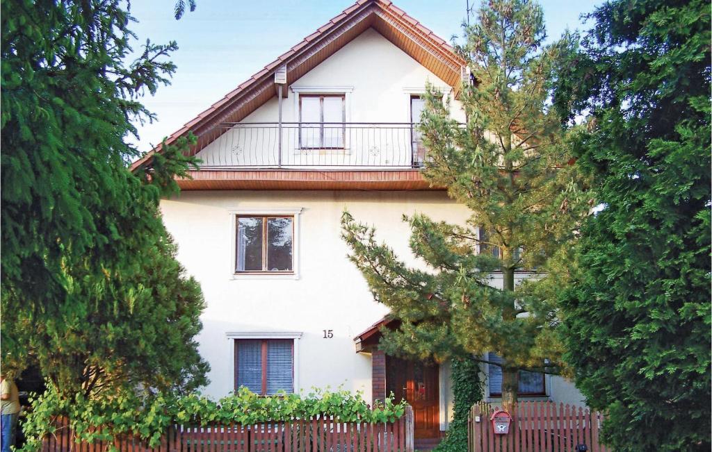 a white house with a fence and trees at Awesome Home In Darlowo With Kitchen in Darłowo