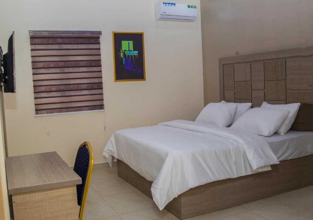 a bedroom with a large bed with white sheets at MITOS LUXURY SUITES (BODE THOMAS) in Lagos