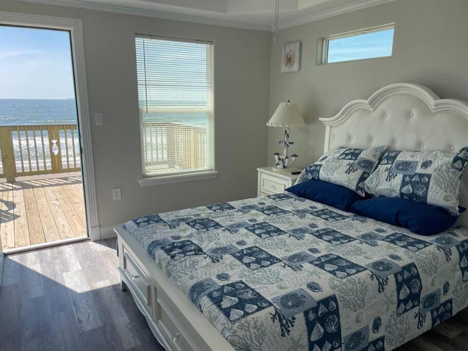 a bedroom with a bed and a view of the ocean at Surfside Beachfront Luxe in Surfside Beach