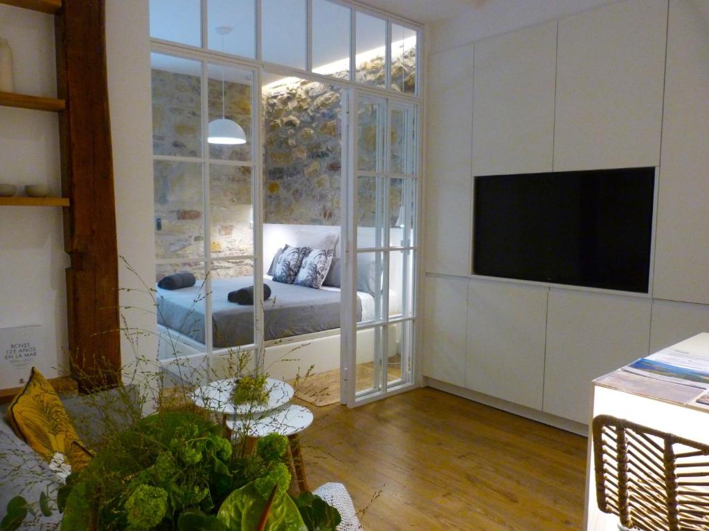 a living room with a couch and a television at Chic Gran Vía, nuevo apartamento de diseño en Gros by ChicDonosti in San Sebastián