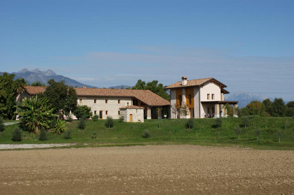 ein Haus auf einem Hügel neben einem Feld in der Unterkunft Country House Due Fiumi in Sacile