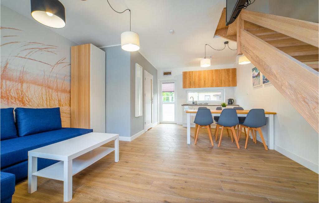 salon z niebieską kanapą i stołem w obiekcie Cozy Home In Rewal With Kitchen w Rewalu