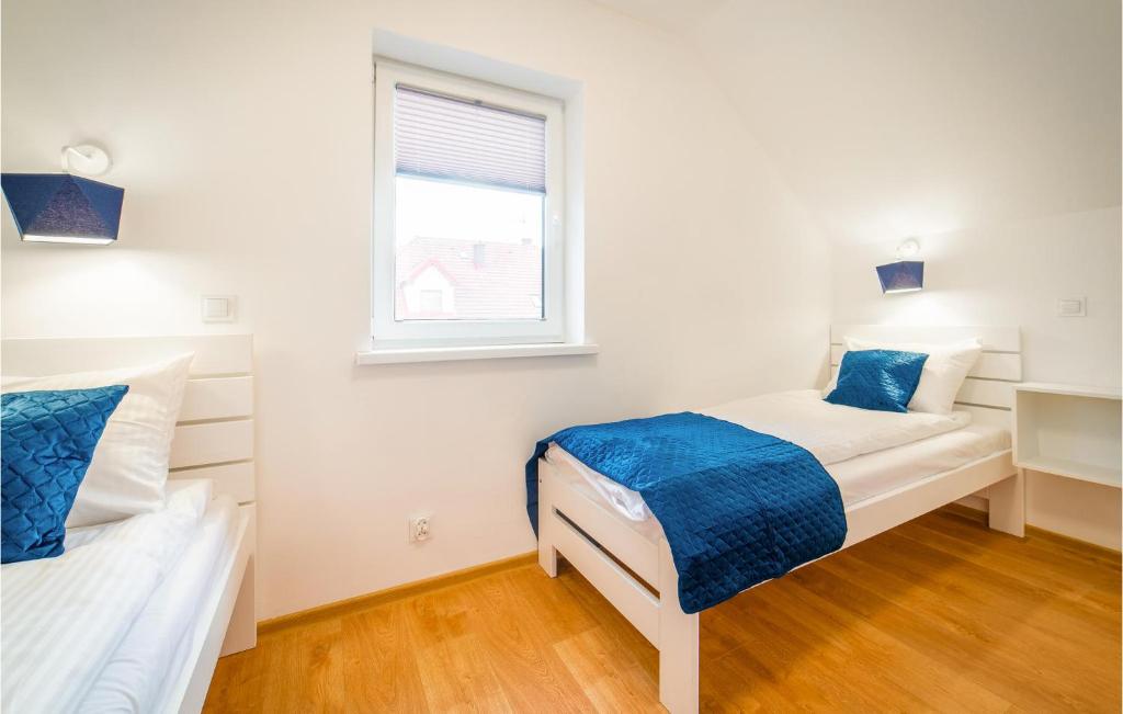 sypialnia z dwoma łóżkami i oknem w obiekcie Cozy Home In Rewal With Kitchen w Rewalu