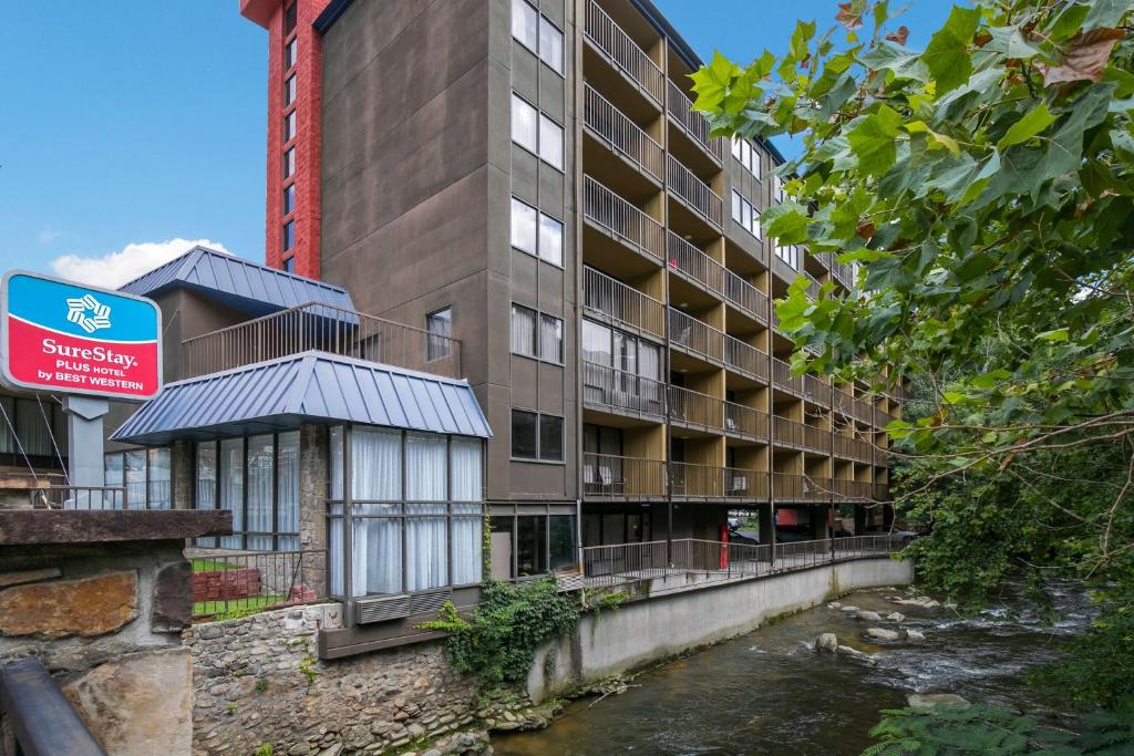 un edificio junto a un río al lado de un edificio en SureStay Plus Hotel by Best Western Gatlinburg, en Gatlinburg