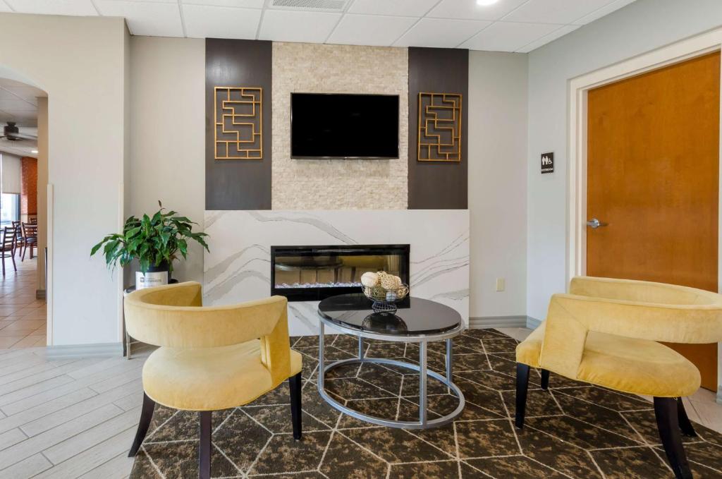 a lobby with a fireplace and two chairs and a table at Best Western North Roanoke in Troutville