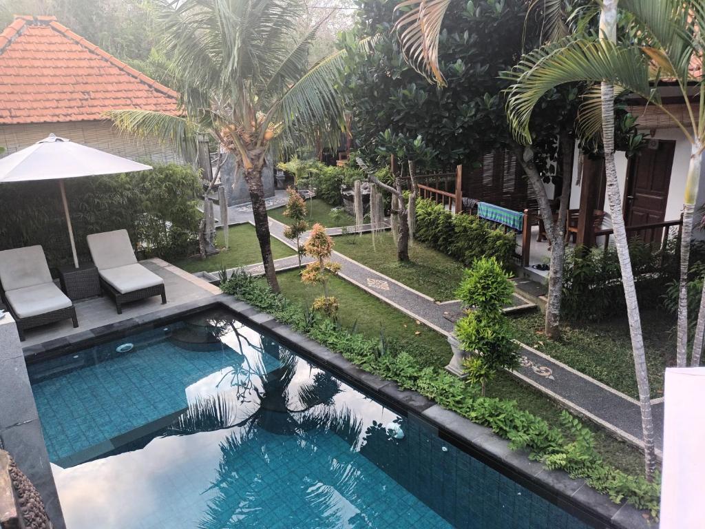 an overhead view of a swimming pool with palm trees at Isola D'oro lembongan in Nusa Lembongan