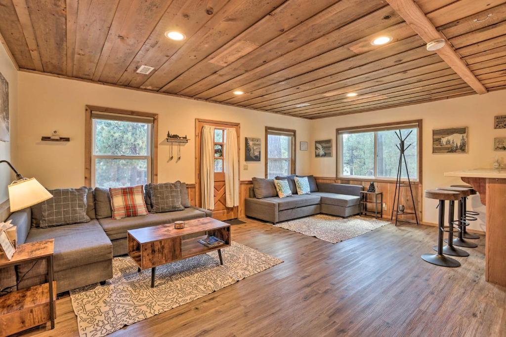a living room with a couch and a table at Peaceful Big Bear Cabin Walk to Lake Access! in Big Bear Lake