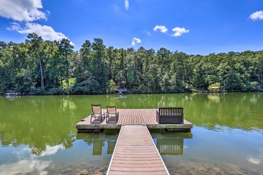 two chairs sitting on a dock on a lake at Charming Georgia Abode with Hot Tub and Grill! in Worthville
