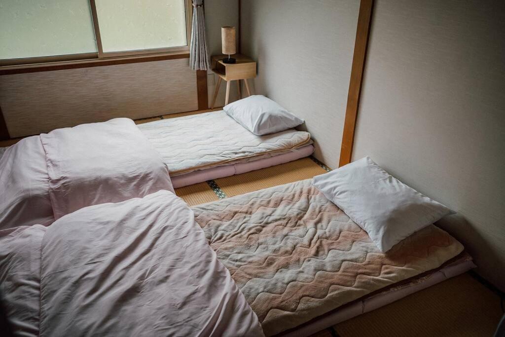 Habitación con 2 camas en una habitación en Vacation House ROMAN, en Noboribetsu