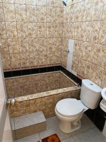 y baño pequeño con aseo y ducha. en Alojamiento Everglow, en Iquitos