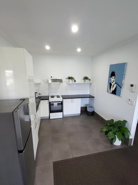 a kitchen with white counters and a stove top oven at Central Motel Mooloolaba in Mooloolaba