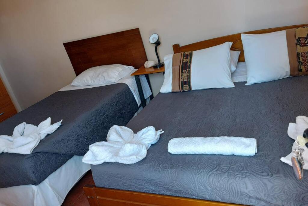 a hotel room with two beds with towels on them at CASA VICTORIA in San Pedro de Atacama