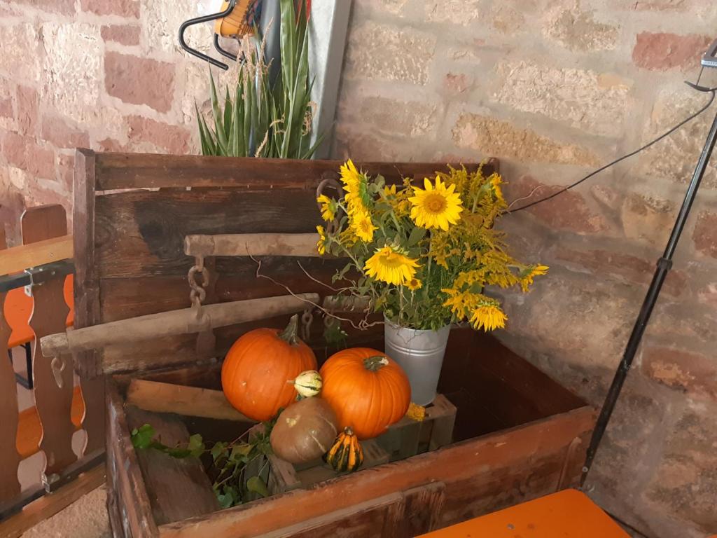 een houten doos met pompoenen en bloemen erin bij Gästehaus Engelhard Pension in Karbach