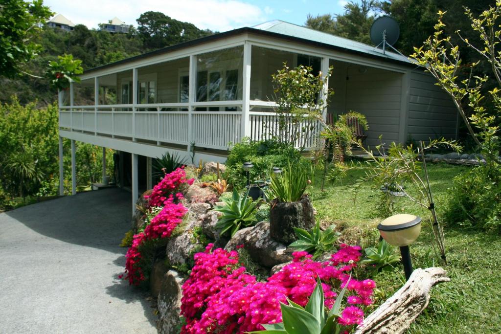 una casa con flores rosas delante de ella en Villa Russell en Russell