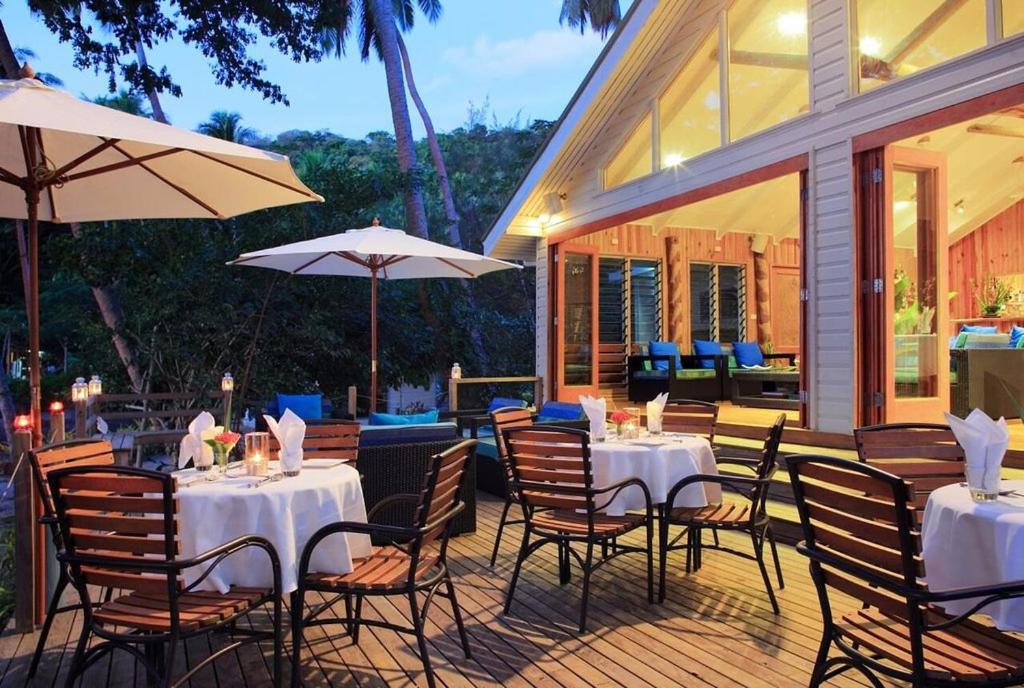 un restaurante con mesas, sillas y sombrillas en Sau Bay Resort & Spa, en Waiyevo