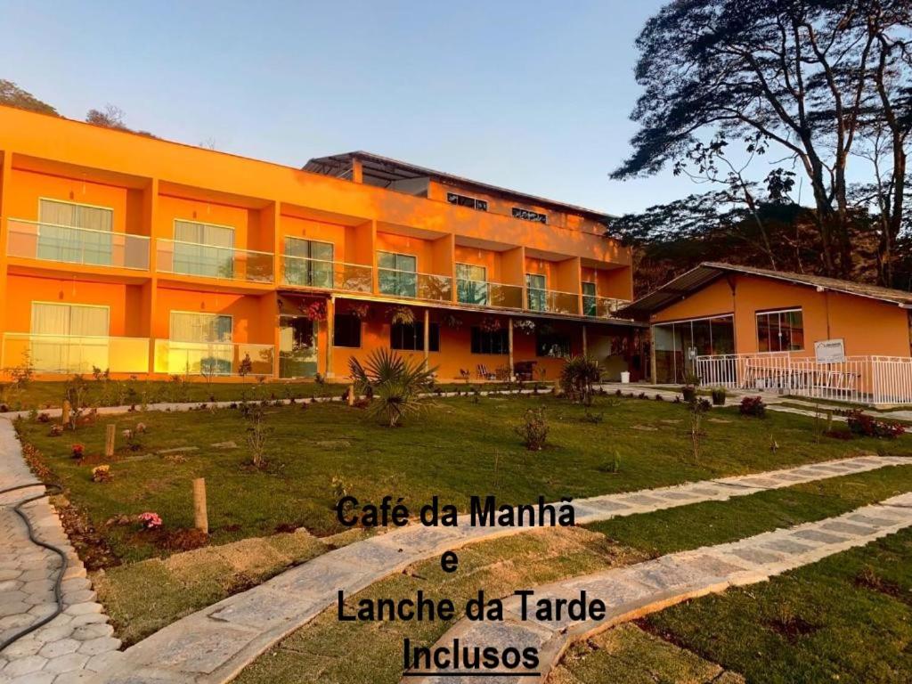 an orange building with a garden in front of it at Pousada Alto da Serra in Conservatória