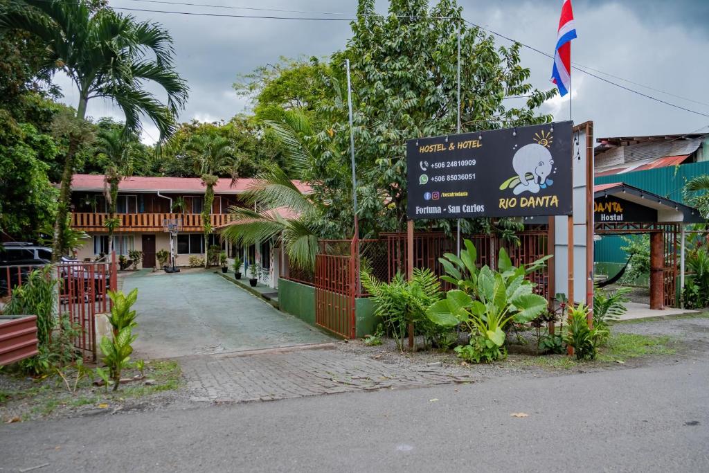 a building with a sign in front of a street at Rio Danta Hostel in Fortuna