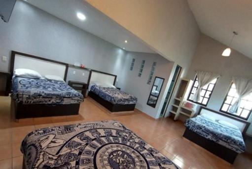 a room with three beds and a couch in it at Hotel Real Campestre Tepetoci in Tepexi del Río