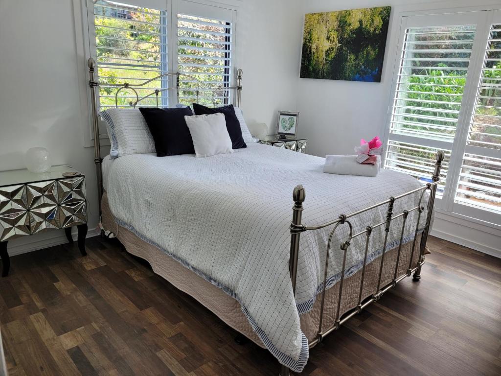um quarto com uma cama grande e 2 janelas em Tambo Tranquility em Mount Tamborine