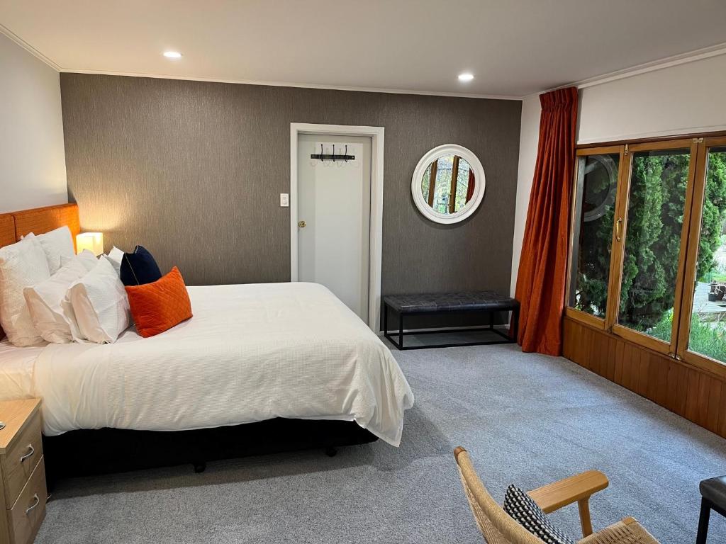 a bedroom with a large bed and a window at Shy Cottage and Studio in Greytown