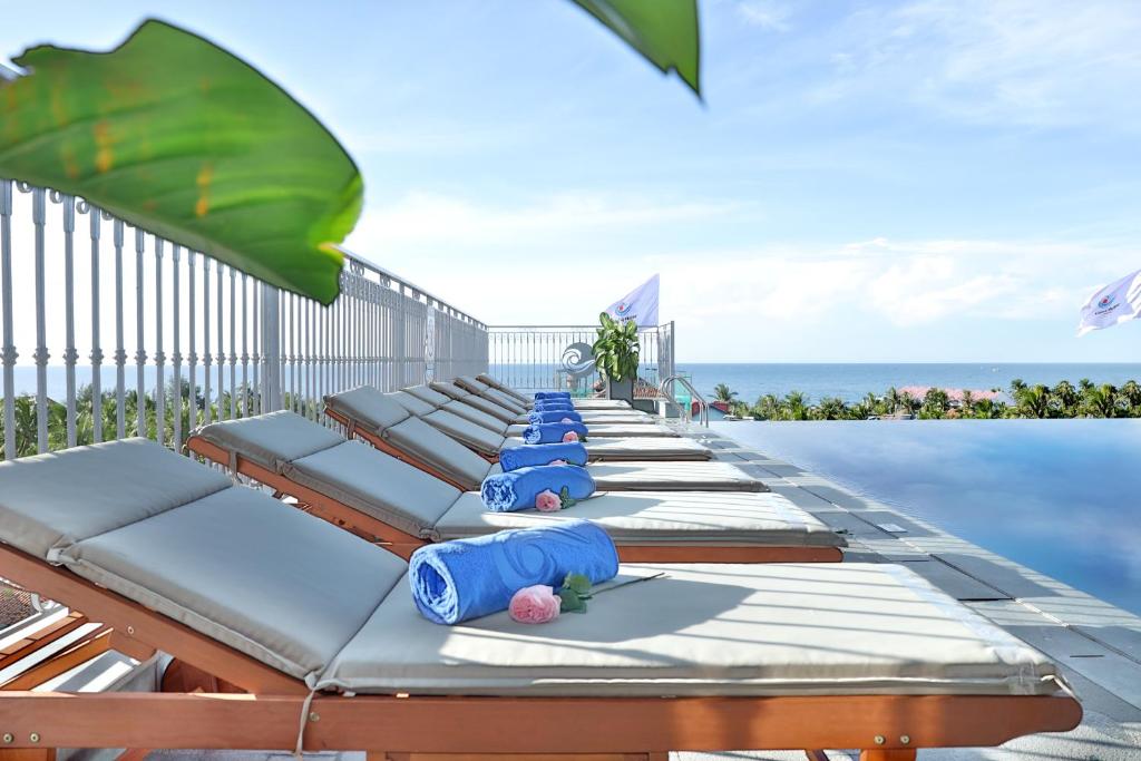 Vipol Mui Ne Hotel & Spa في موي ني: مجموعة من الصالات علي حافة حمام السباحة
